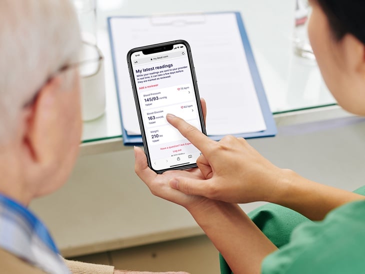 Clinicians reviewing patient data from mobile device